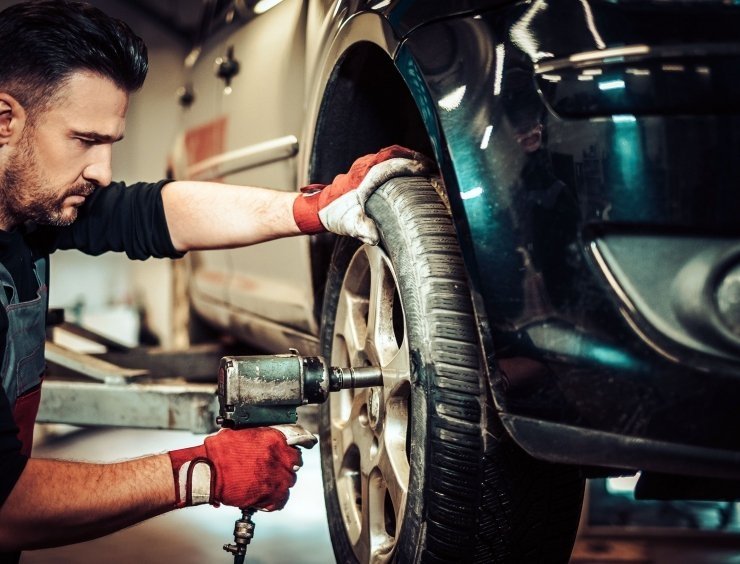 muž pracující na pneumatice v garáži