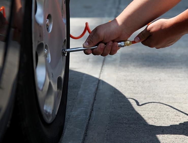 muž mění pneumatiku u auta